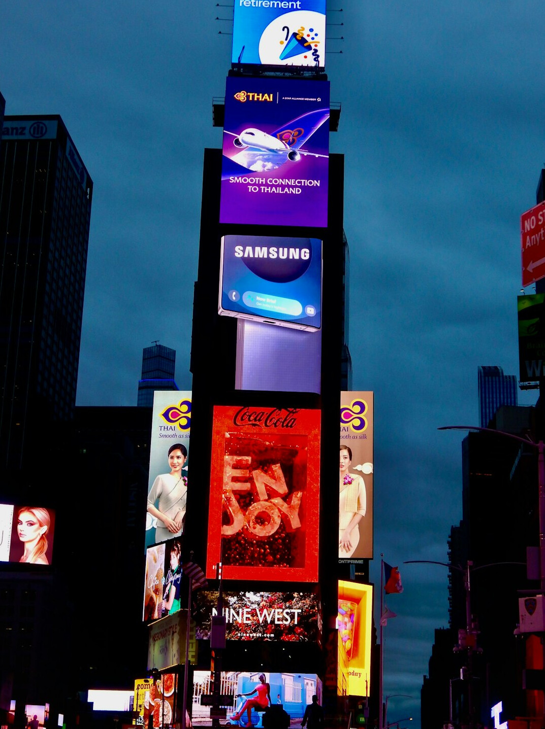 City skyline at dusk with illuminated digital advertising screens