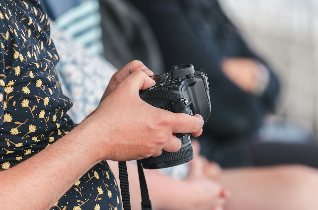 Photographer holding a professional camera at a press event